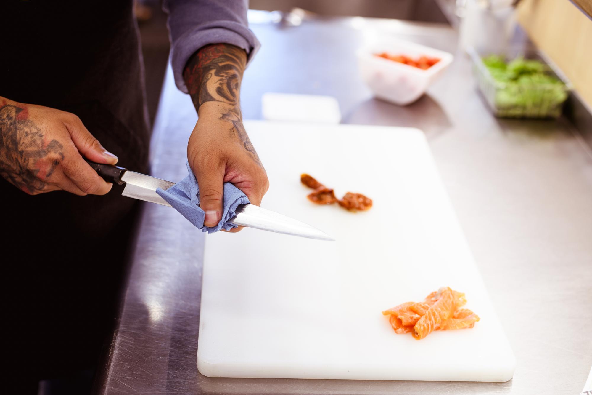 Chef che spiega tecnica di taglio in cucina professionale